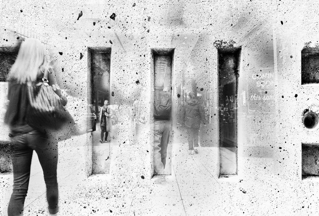 The image is a monochrome collage where people appear to walk through large vertical gaps in a textured concrete wall. The figures are semi-transparent, blending with the rough surface, as if merging with their surroundings.